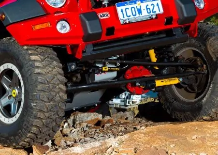 OME 4 inch Lift Kit installed of a red Jeep Wrangler JK 2007-2015 front close up